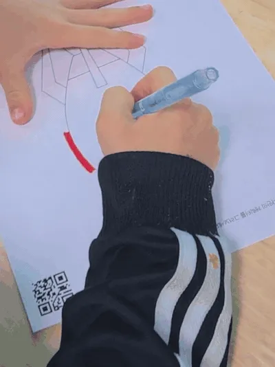 絵に色を塗る手元と紙を切り出した短い動画