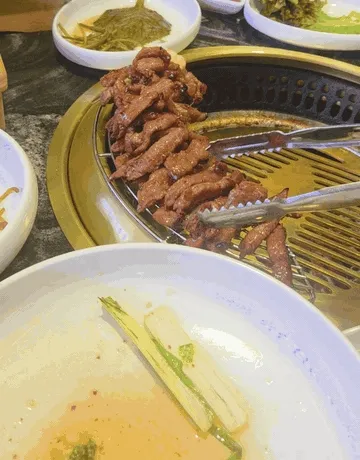다 익은 갈매기살을 집게로 들어 올리는 모습 (움짤)