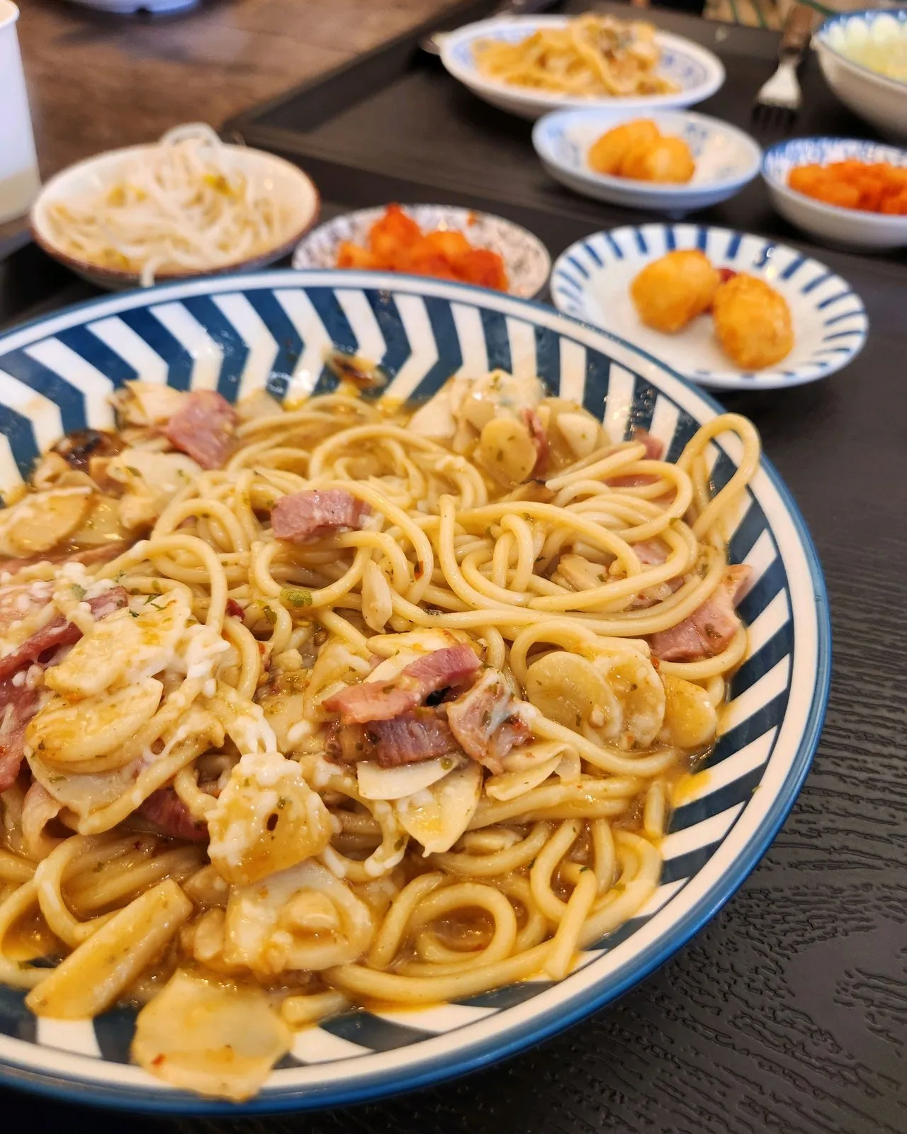 훈제 베이컨 마늘 파스타 — 진한 소스에 베이컨과 마늘이 넉넉히 들어갑니다. 옆에 김치와 반찬 종지들