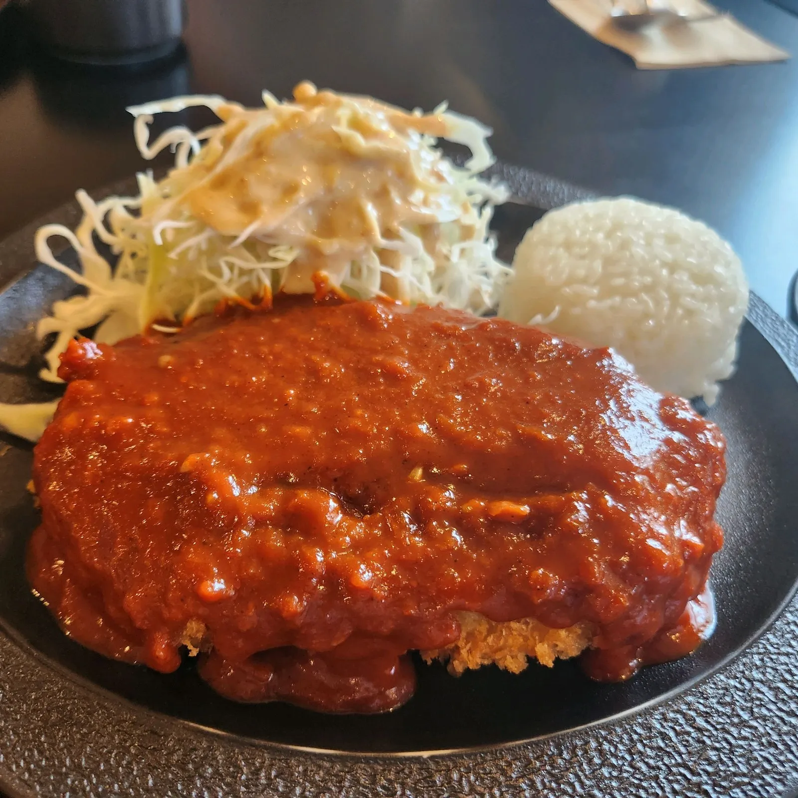 매운돈카츠 — 바삭한 돈까스 위에 붉은 소스가 듬뿍, 옆에 양배추 샐러드와 밥