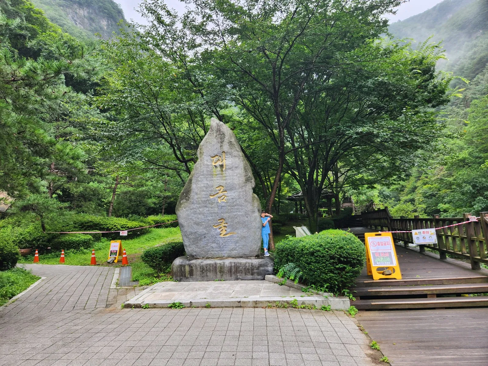 대금굴 표지석 — 큰 자연석에 세로로 새긴 금색 글씨, 뒤로는 안개 낀 산