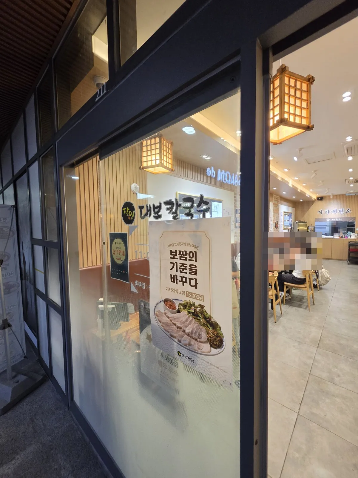 상가 통로 쪽 입구 — 유리문 너머로 자가제면소가 보입니다