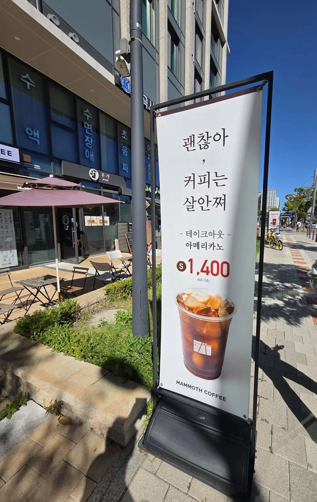 가게 앞 배너 — '괜찮아, 커피는 살안쪄', 테이크아웃 아메리카노 S 1,400원(ICE 기준)
