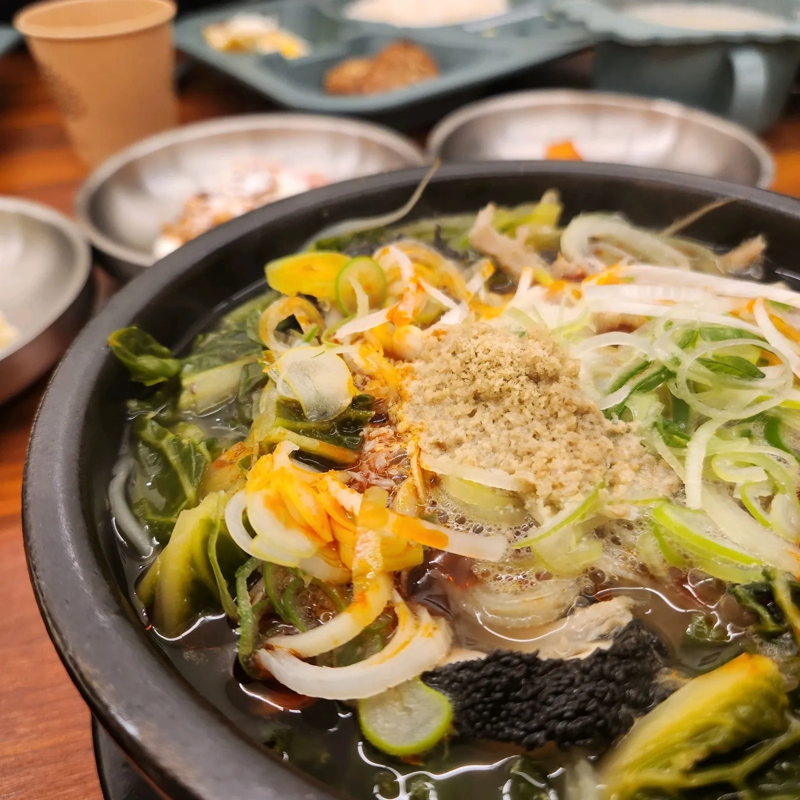 해장국 — 초록 채소가 가득하고 고운 가루 고명이 올라갑니다