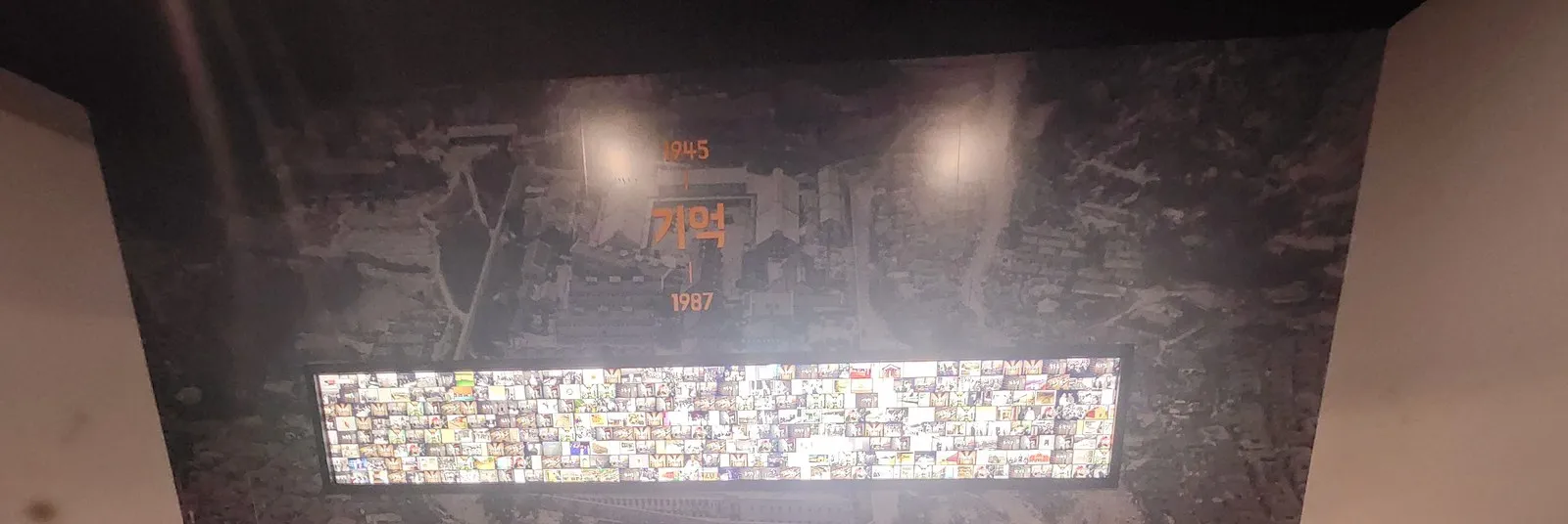 2026년 6월 13일 17:35 — '기억 1945 · 1987' 벽과 사진벽 전시. 아이가 앉아 있던 벤치 쪽은 잘라냈습니다