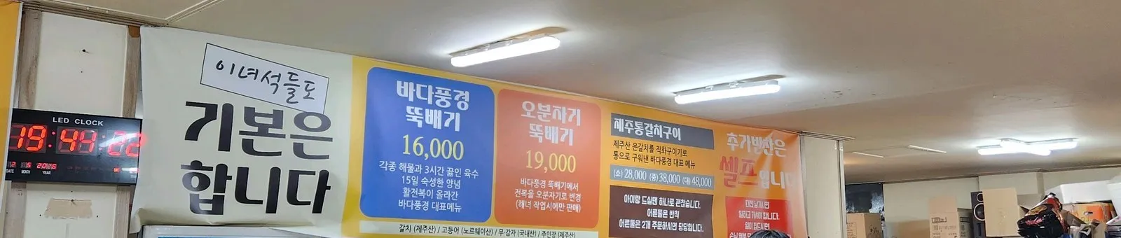 두 번째 현수막 — 바다풍경 뚝배기 16,000 · 오분자기 뚝배기 19,000 · 제주통갈치구이 소 28,000 / 중 38,000 / 대 48,000. 왼쪽 LED 시계는 19시 44분