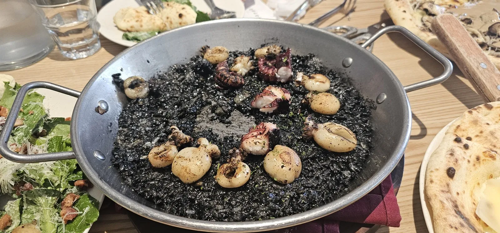 먹물 빠에야 — 팬 가득 먹물 밥에 베이비 오징어와 문어 다리