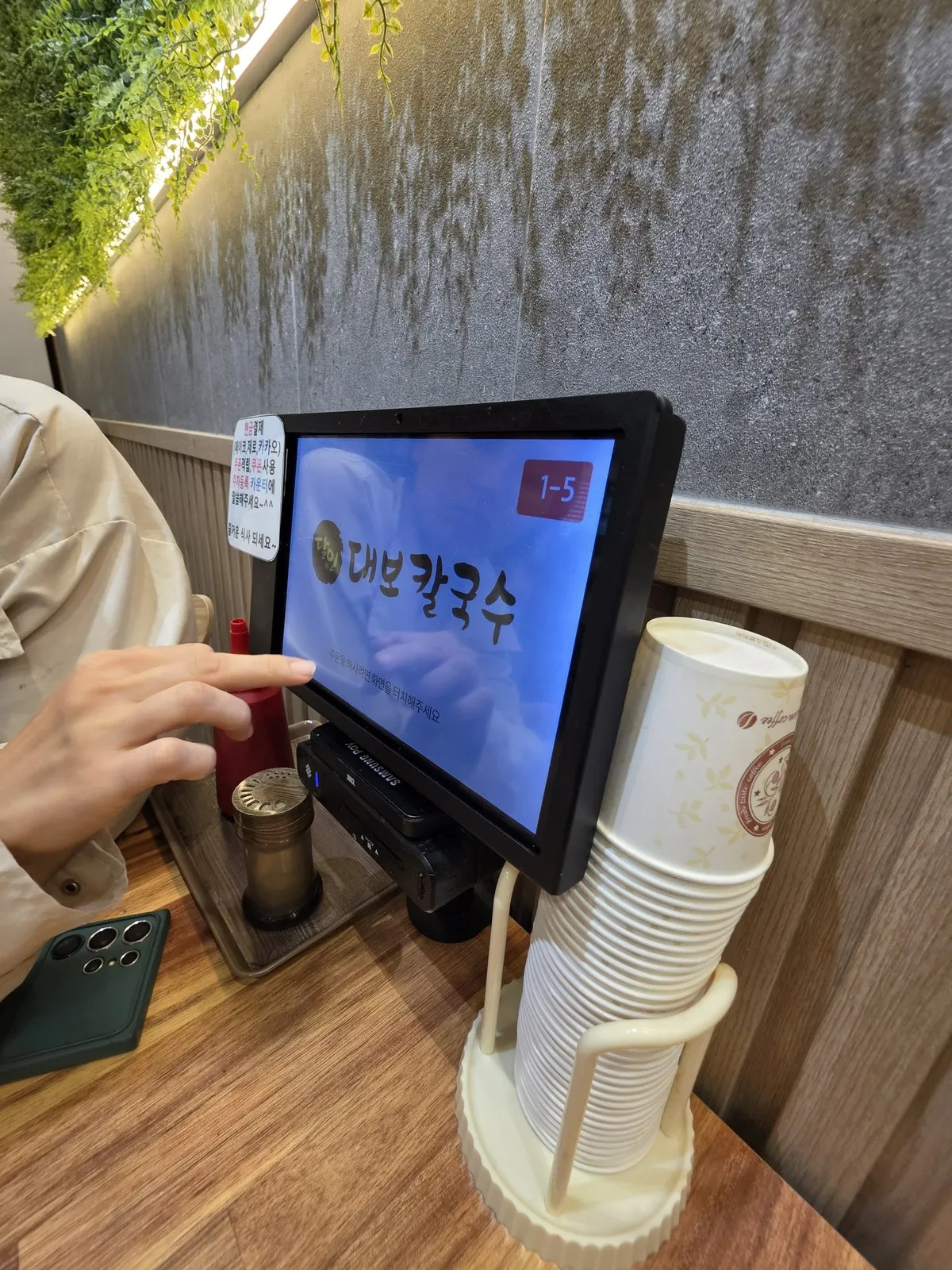 테이블 태블릿 주문기와 결제·주차 안내문