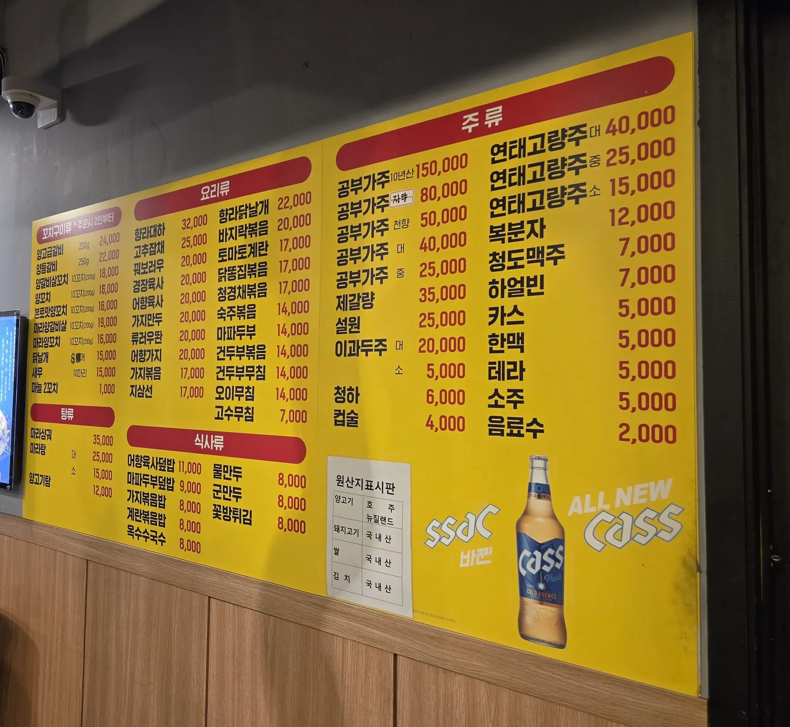 The yellow menu board on the wall