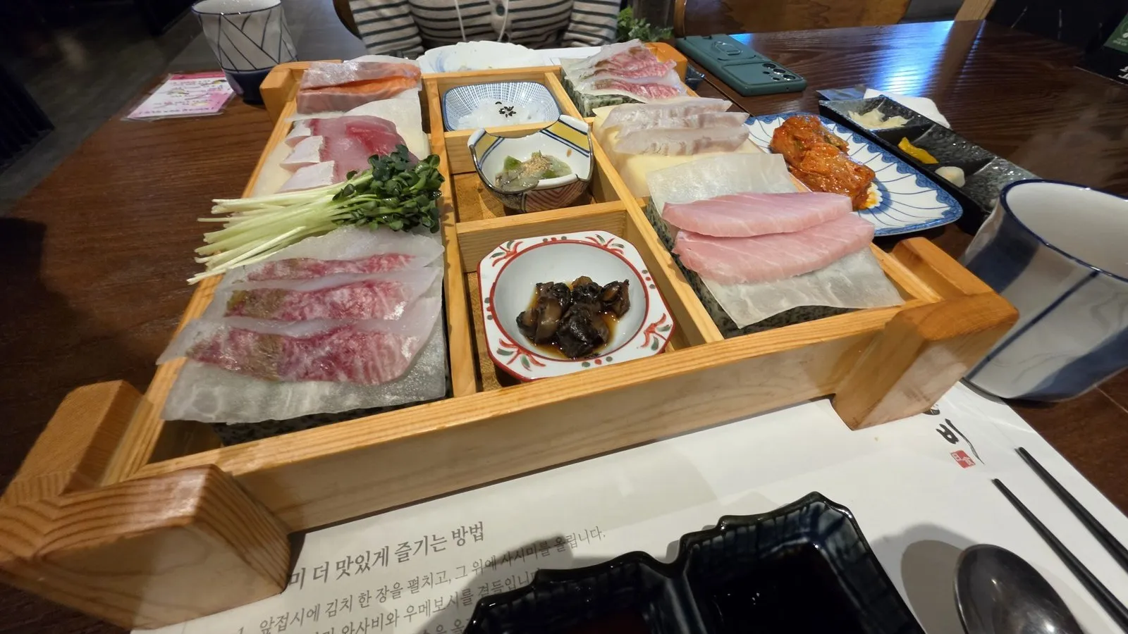 나무 칸에 담긴 회와 곁들이 찬, 회를 싸 먹을 김치