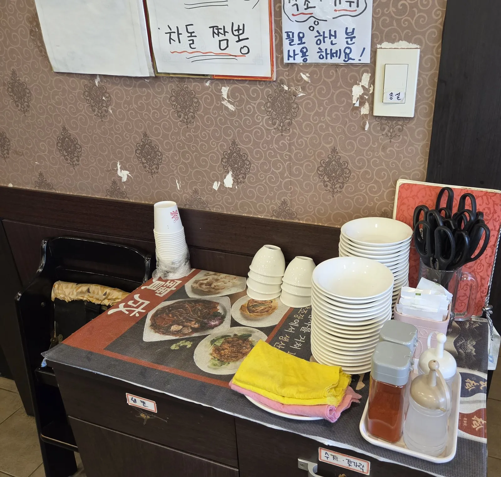 The self-service corner with plates, towels and scissors