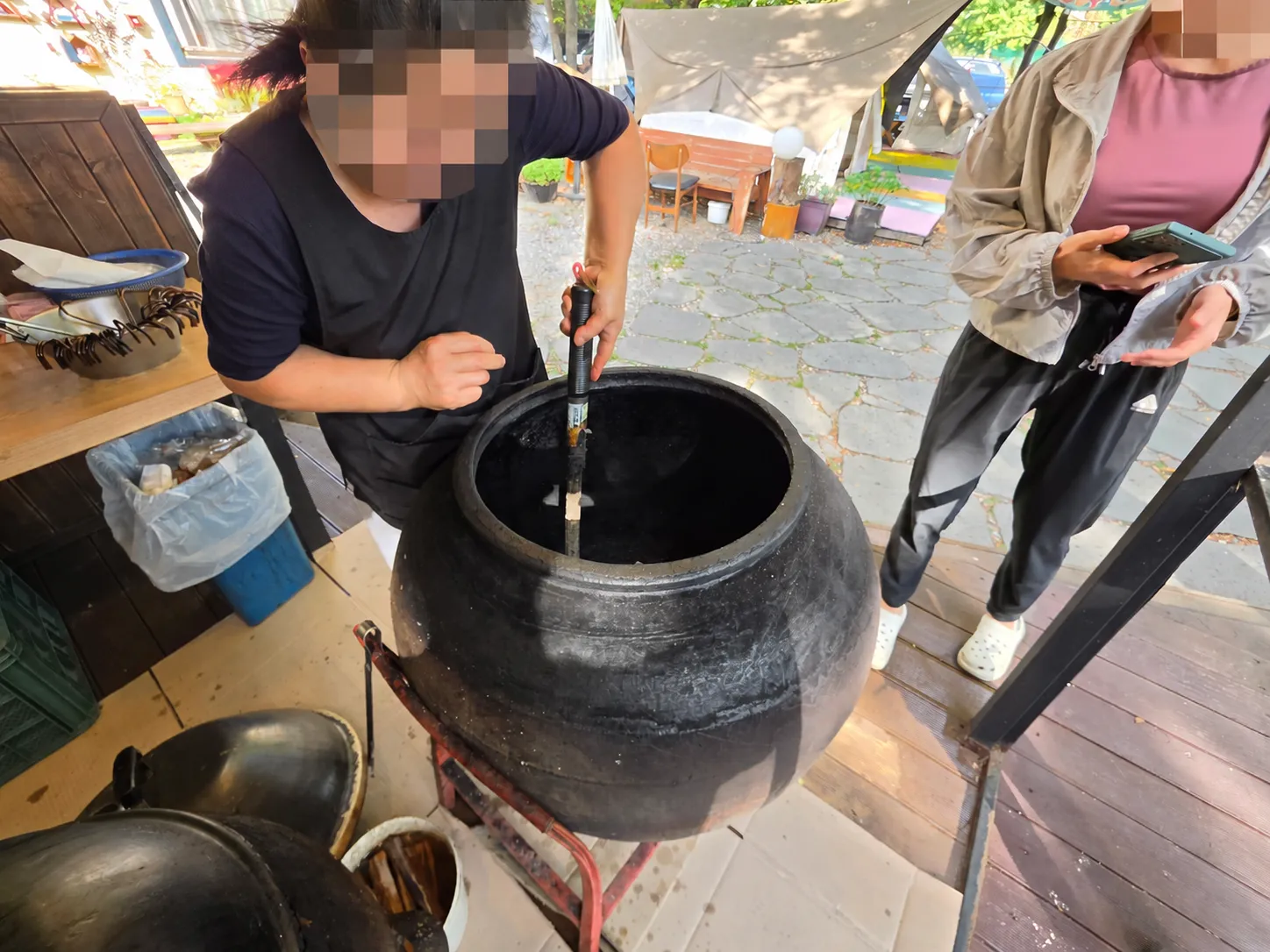 壺を開けて中を見せてくれる調理風景
