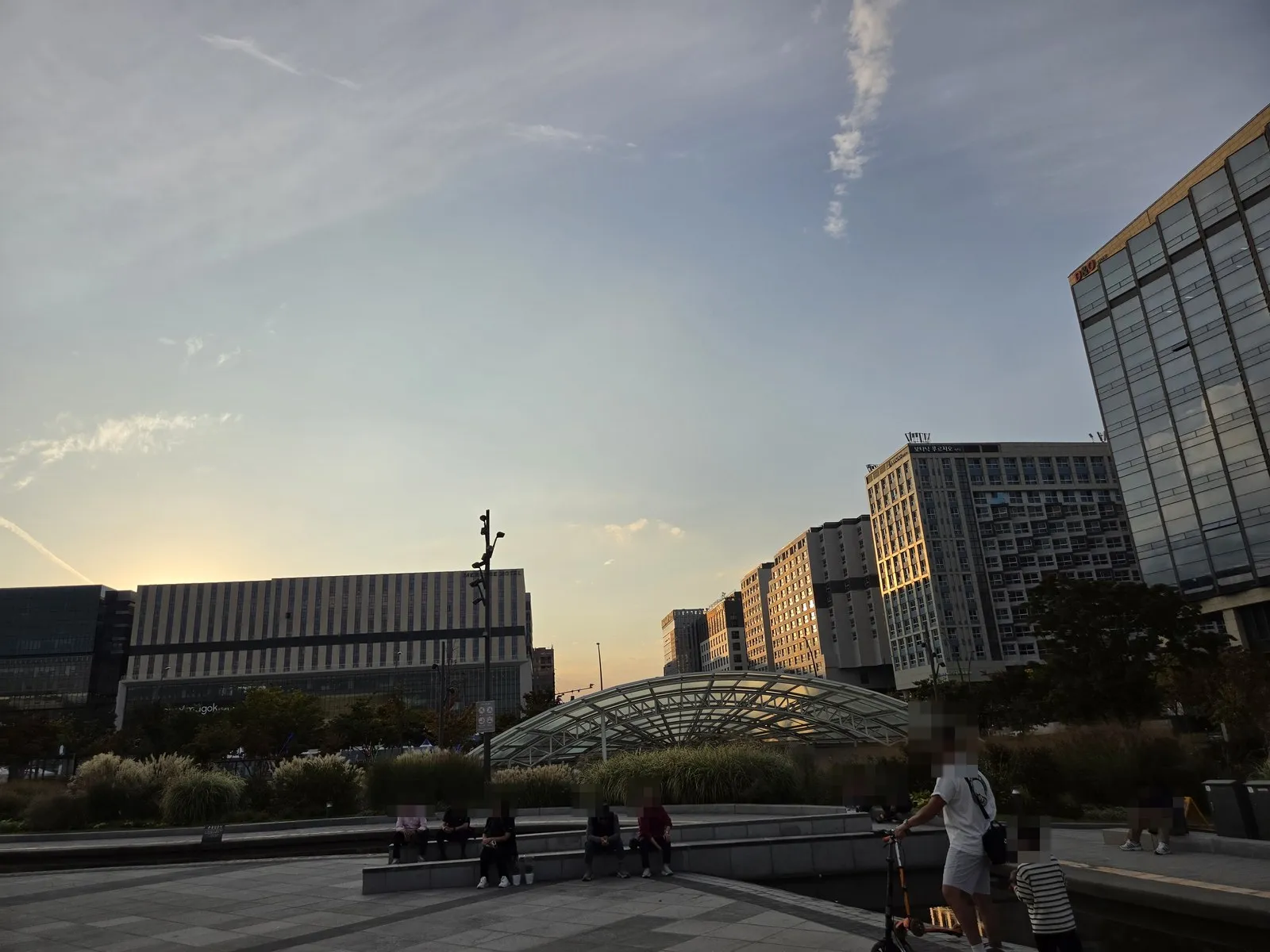 The plaza at sunset · a glass dome building and tall buildings