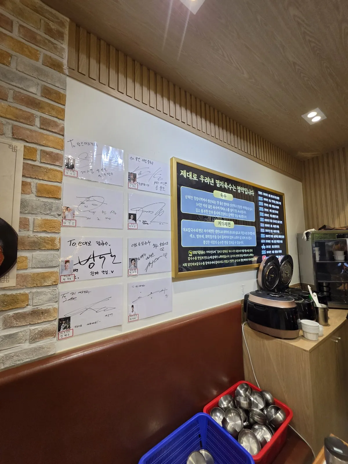 멸치육수·자가제면 안내판과 방송 이력, 왼쪽은 방문 사인들