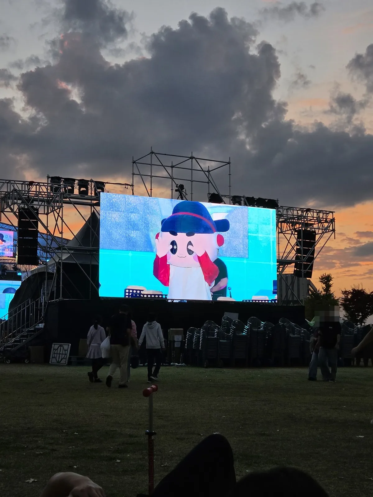 A Heo Jun character doll on the stage screen at dusk