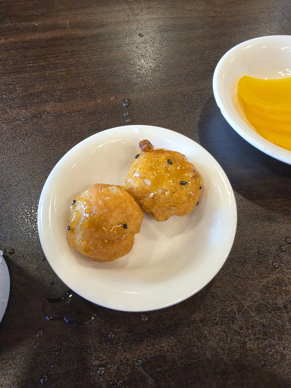 Two round fried balls on a small plate