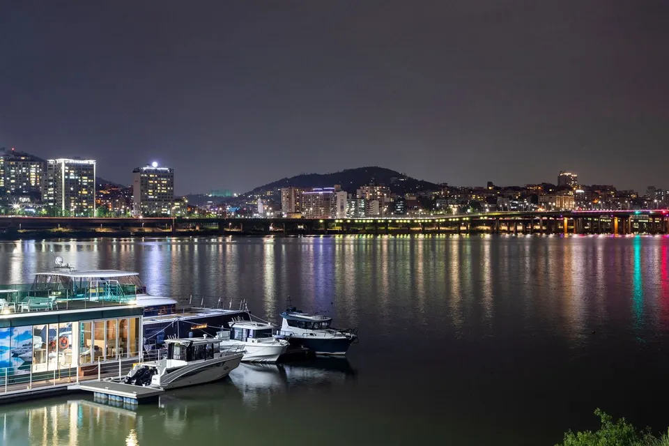 蠶院漢江公園 — 漢江水面與河畔城市夜景，以及停泊的船隻（2020年5月）