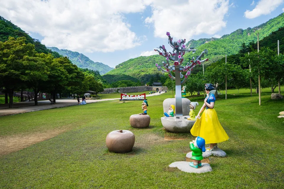 聞慶鳥嶺道立公園 — 以山與城牆為背景的公園造型物與草坪廣場（2024年5月）