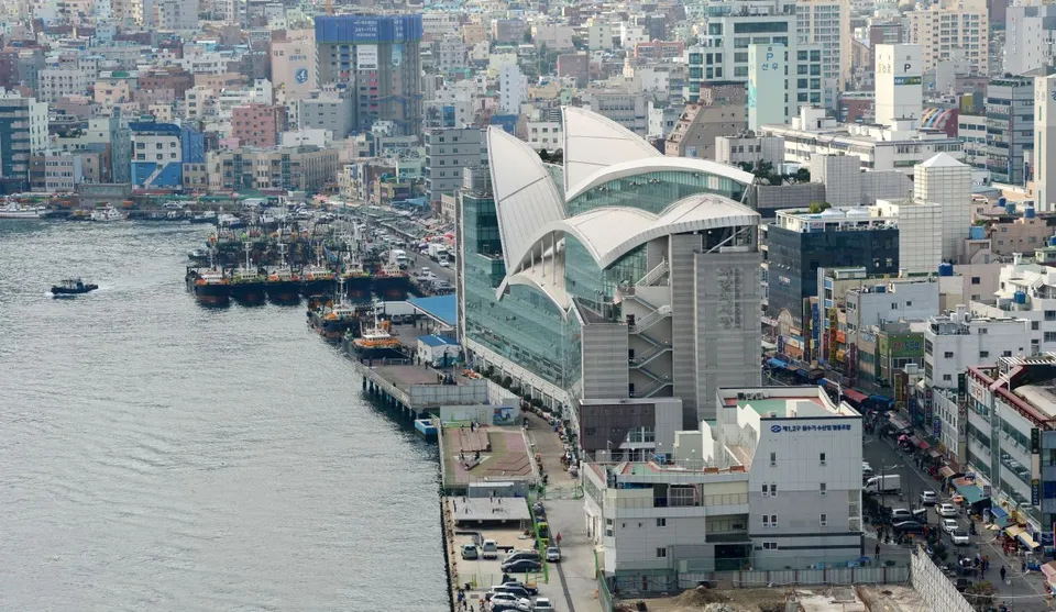 札嘎其市場 — 沿海而建的白色曲線屋頂市場大樓與停泊的船隻（2020年）