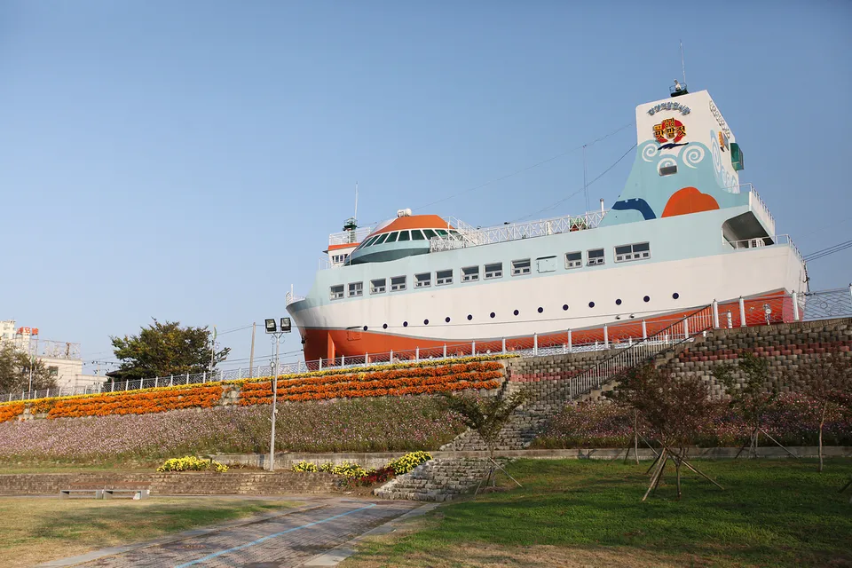 江景醃海鮮展示館 — 船形建築與斜坡上的花圃（2012年10月）