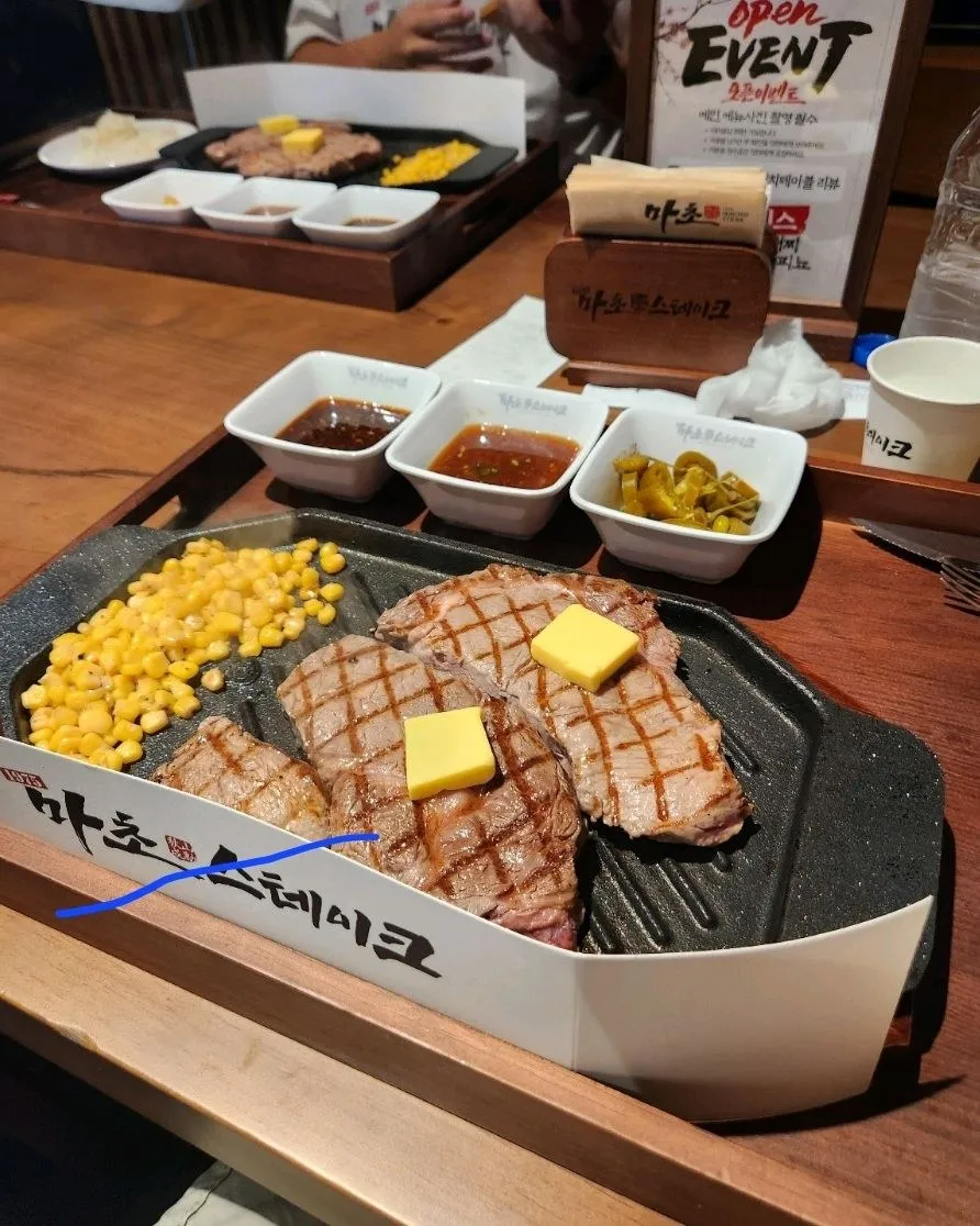 첫 방문 — 스테이크 두 덩이, 소스 3종과 피클, 옥수수 구성