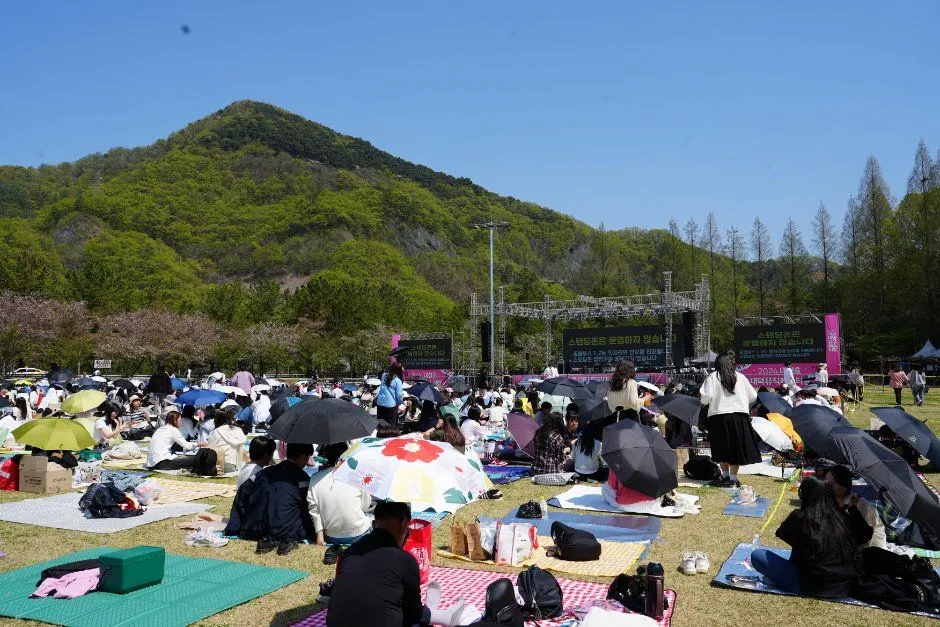 지난 축제 — 산 아래 잔디밭에 모인 축제 관람객