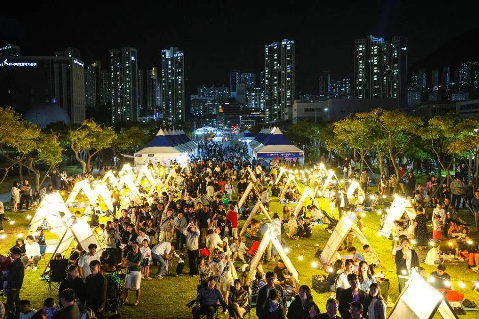 2025年慶典 — 在夜間草地上享受露營的遊客