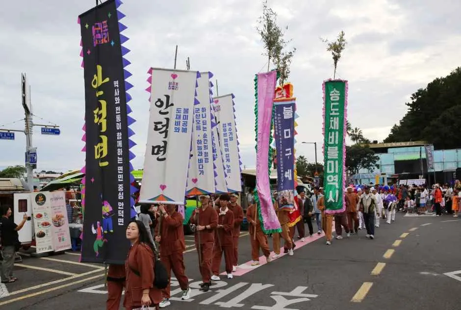 往屆活動 — 在街道上手持旗幟遊行的慶典參加者（照片：韓國觀光公社・公共授權第3類）