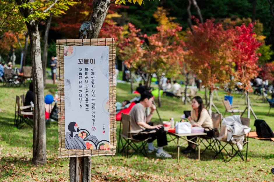 往屆活動 — 秋日公園中的導覽橫幅與休憩遊客