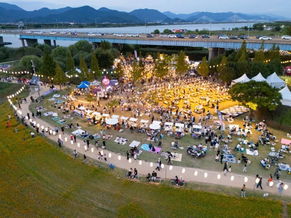 往屆活動 — 聚集在河畔活動場地與戶外餐桌旁的人們