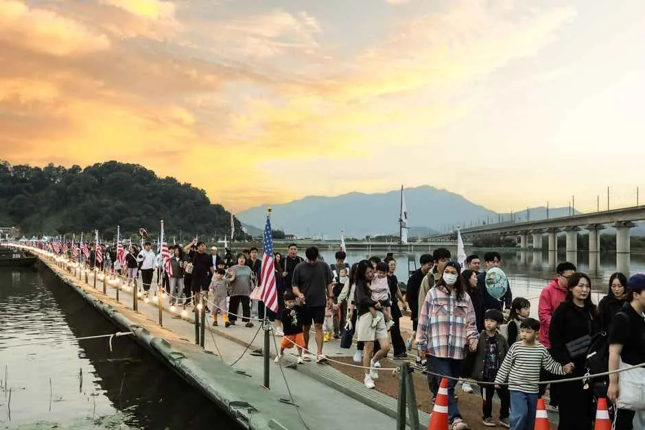 往屆活動 — 走在河上浮橋上的市民與飄揚的旗幟（照片：韓國觀光公社・公共授權第3類）