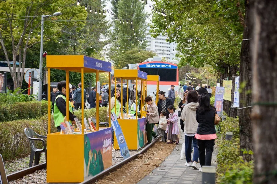 往屆活動 — 有黃色書籍展示攤位與訪客的林道