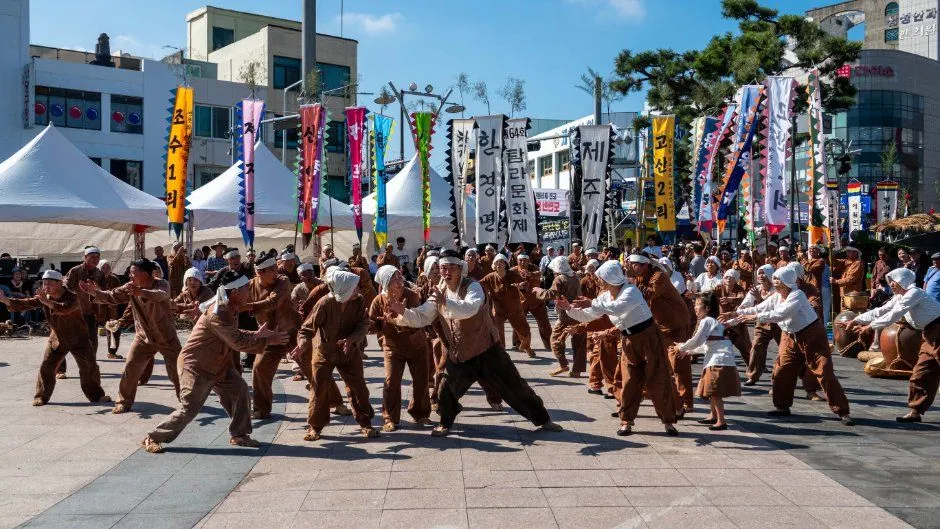 往屆慶典的廣場表演 — 身穿褐色服裝齊舞的表演團與旗幟