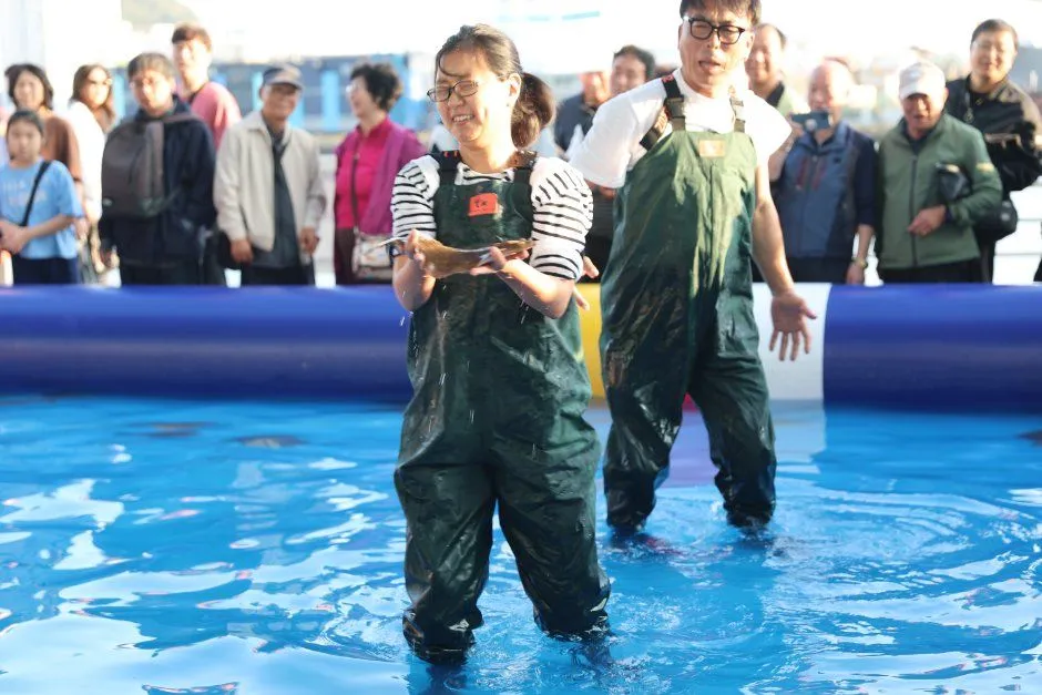 往屆慶典 — 穿著青蛙裝在水池裡抓到魚的參加者（照片：韓國觀光公社・公共授權第3類）