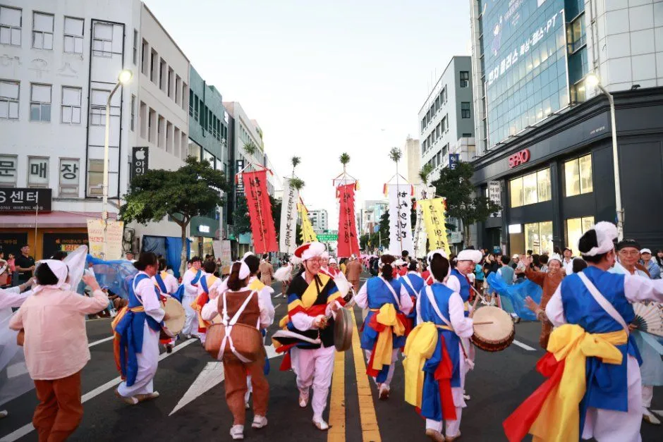 往屆慶典的街頭遊行 — 繫著彩色腰帶、演奏農樂的隊伍