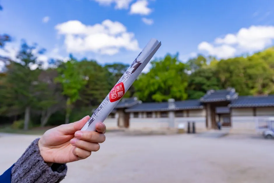 往屆慶典 — 蓋有紅色印章的卷軸與後方的瓦頂建築